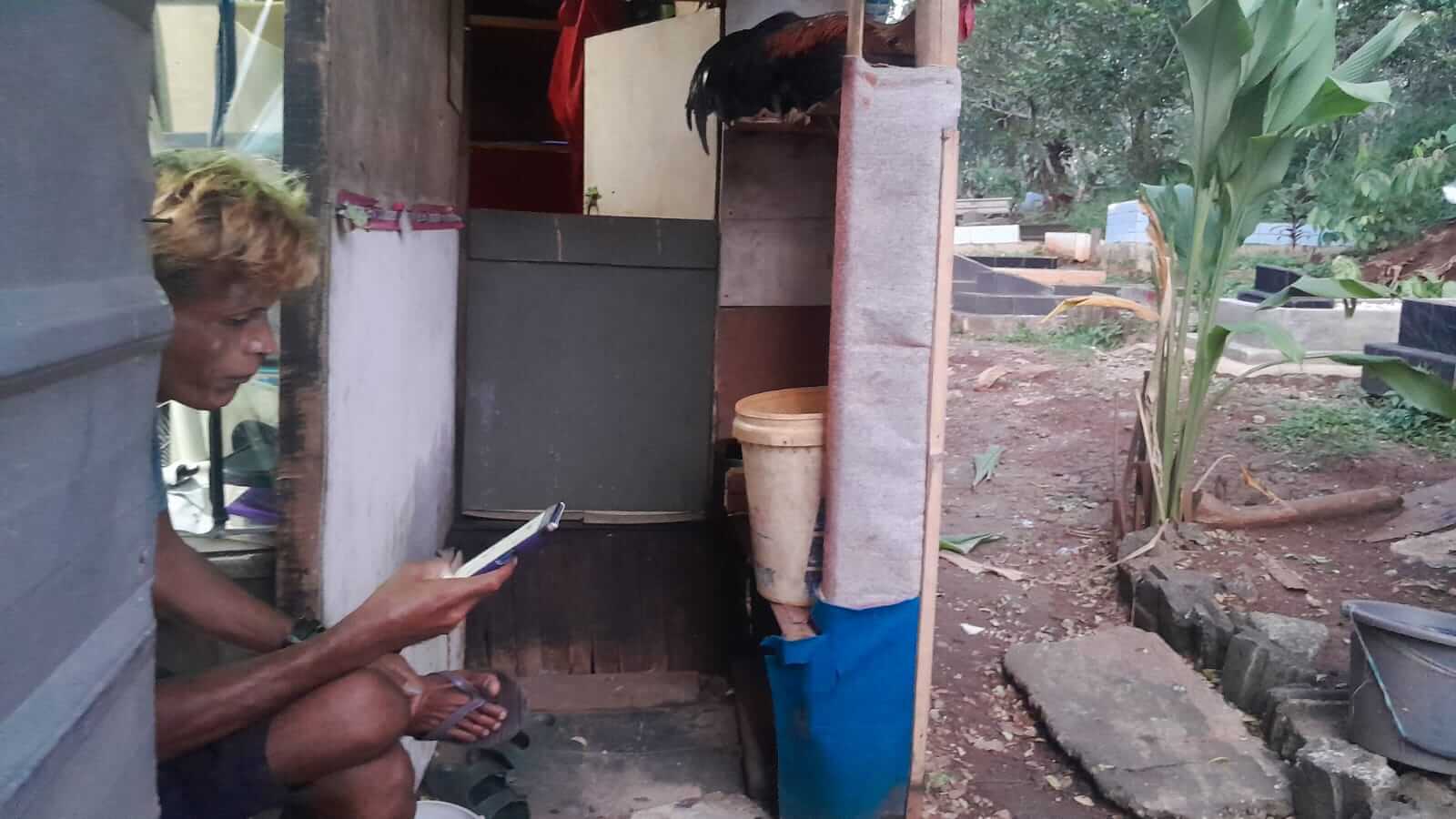 Tampak IS tengah meratapi nasib di area Pemakaman. Hidupnya terpuruk akibat keranjingan Judi Online dan terlilit hutang pinjol. (Foto : iNewsBogor.id/Martin)